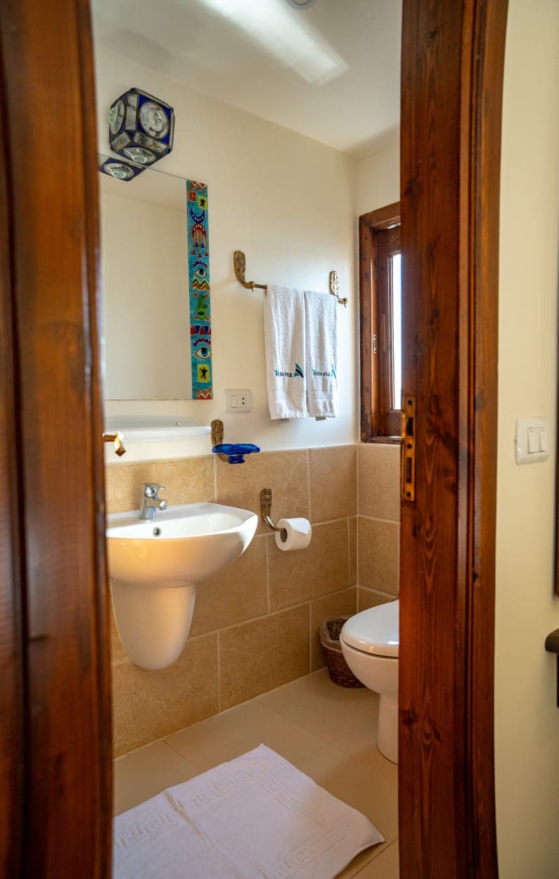 Private bathroom entrance framed in warm natural Egyptian timber