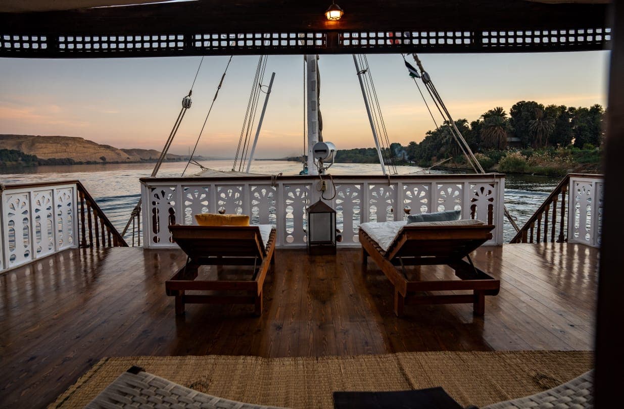 Bow loungers facing the serene Nile river at golden hour