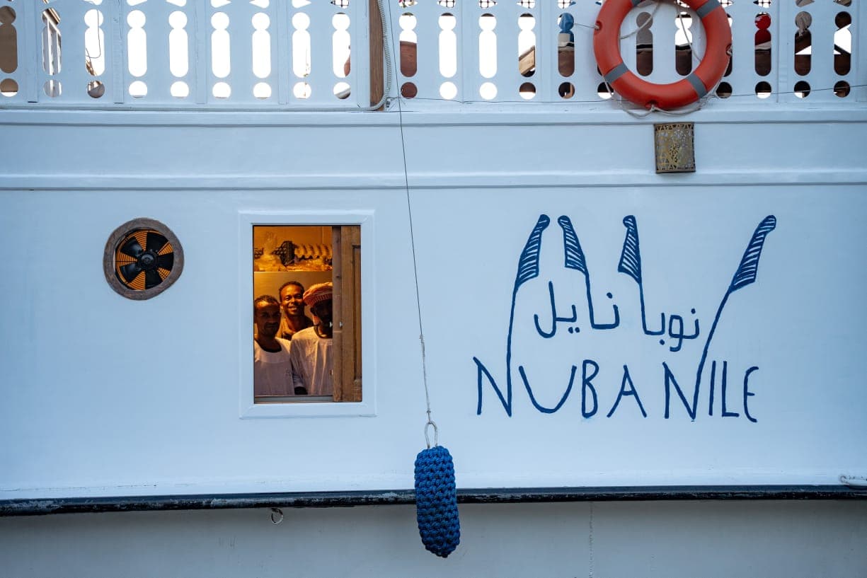 Galley chefs smiling through the window of the Nuba Nile