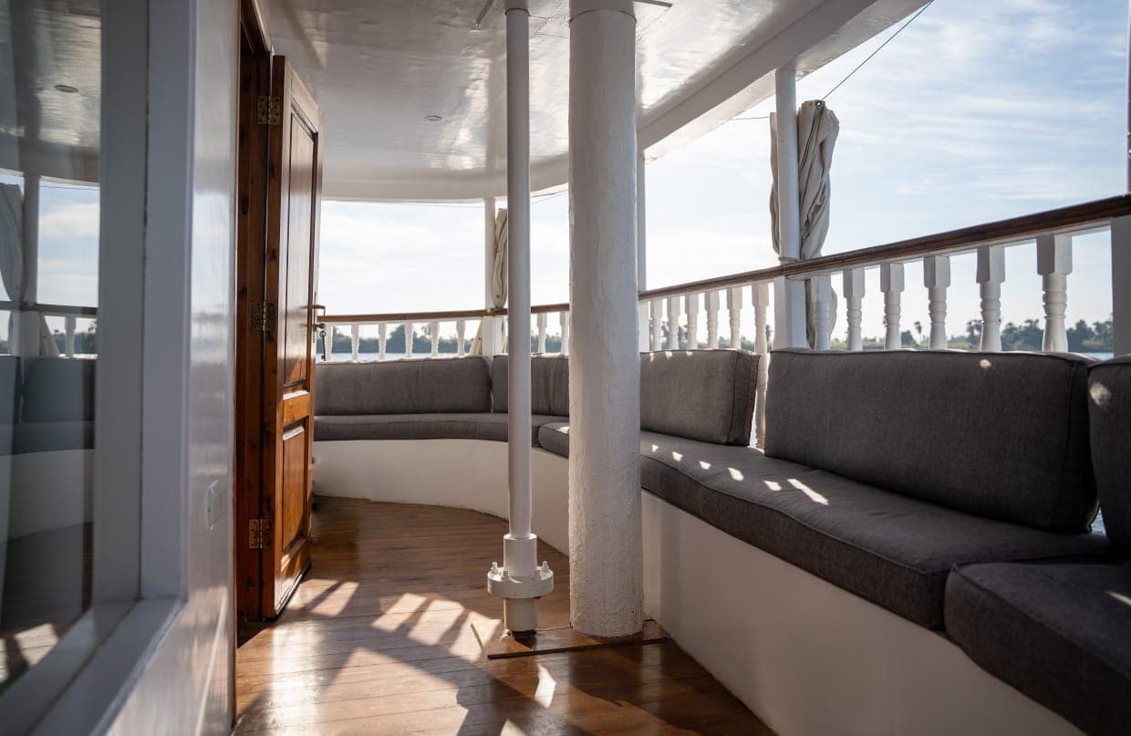 Private stern balcony with curved sofa overlooking the wake
